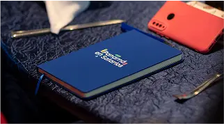 Libreta corporativa azul con logotipo de Panamá en Salarios sobre mesa de evento